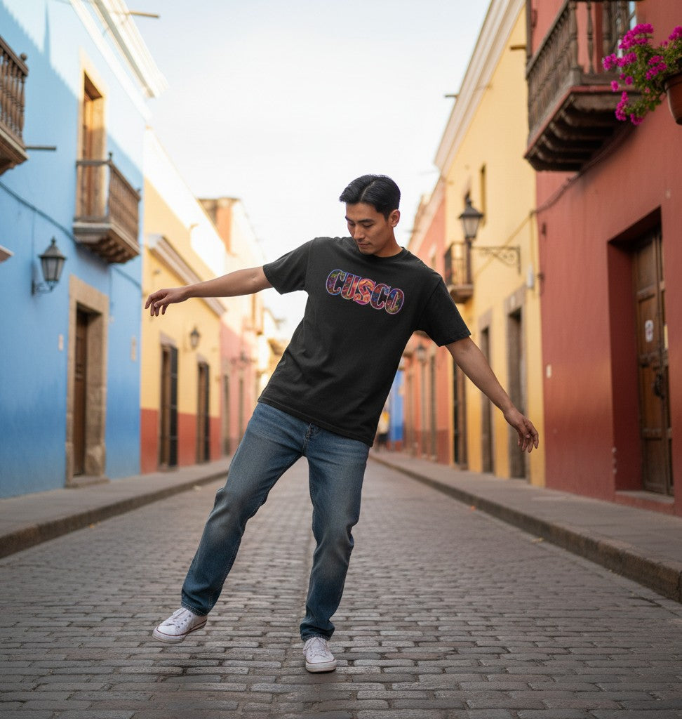 Todo Tumi black 100% cotton Cusco Inti Raymi graphic tee worn by a man on a colorful cobblestone street.