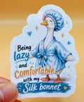 Todo Tumi laminated sticker featuring a hand-drawn goose in a blue robe and silk bonnet with funny text.