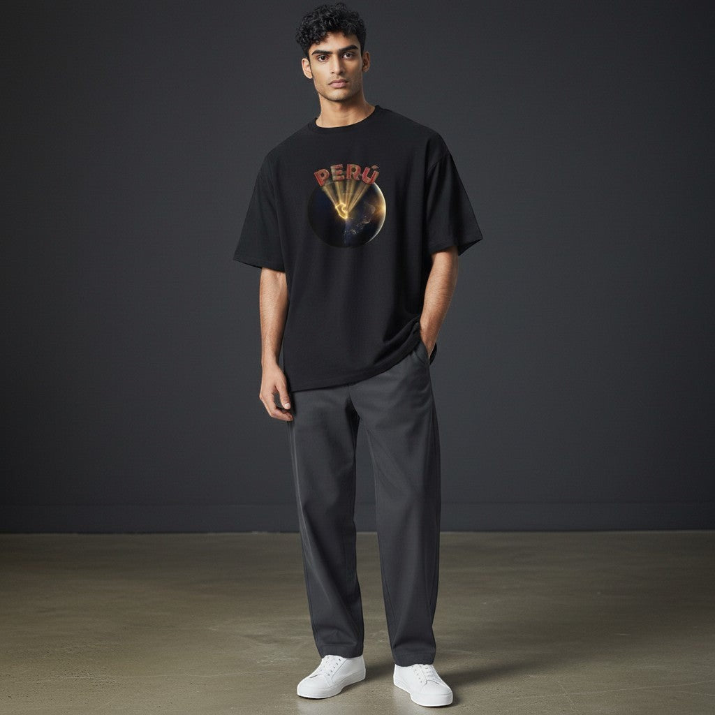 Model wearing a black Todo Tumi 100% cotton Perú From Space graphic tee with a globe and golden light design.