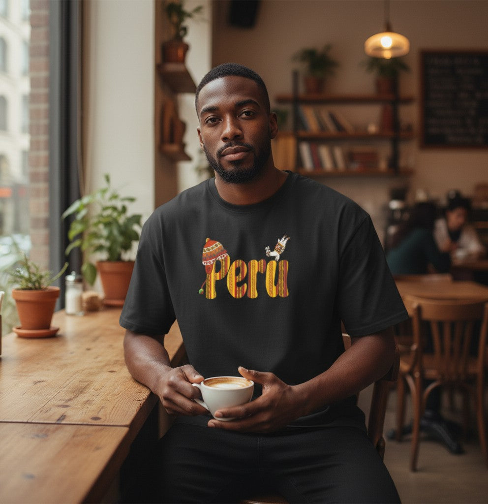 Man wearing a black Todo Tumi Perú Golden Sunset cotton tee with Andean-inspired graphic in a cafe setting.